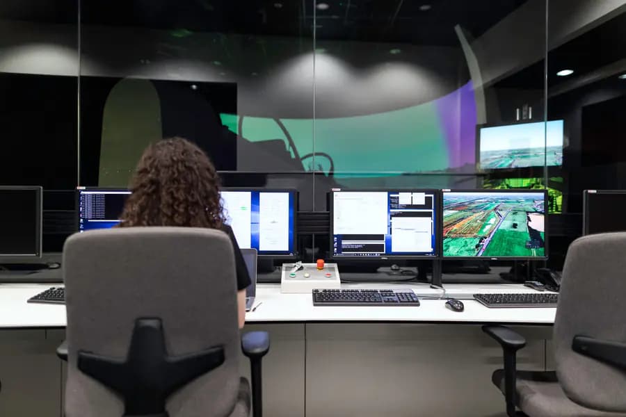 Engineer operating a multi-screen aviation simulation system