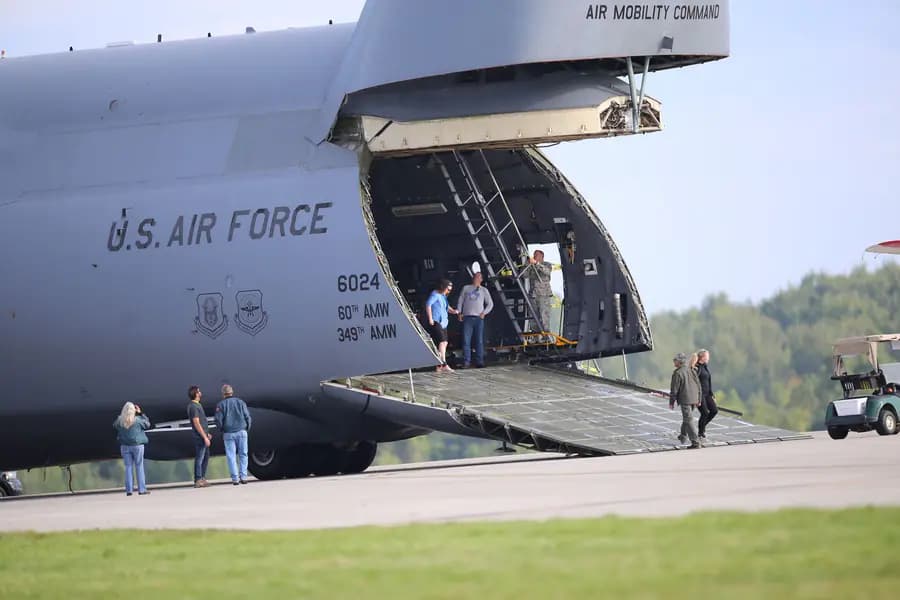 Air mobility personnel operating beside a military cargo aircraft